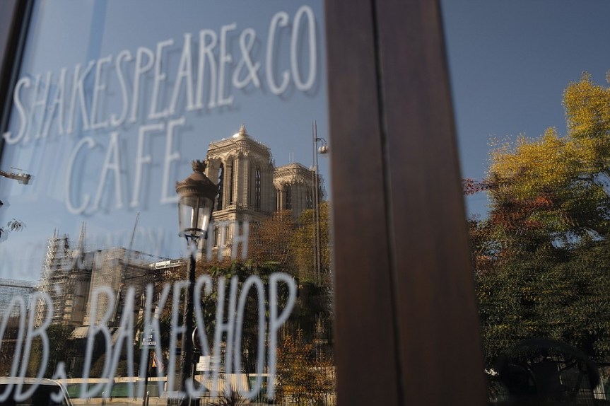 The Notre Dame cathedral is reflected in a window of the closed English and American literature Shakespeare and Co. bookstore, in Paris, France, Thursday, Nov. 05, 2020. Iconic Parisian bookshop Shakespeare and Co. has launched a support appeal to its readers after its owners say that coronavirus-linked losses, and a crippling months-long lockdown, have left the future of the veritable institution in doubt. "We've been minus 80 percent since the first confinement in March, so at this point we've used all our savings," Sylvia Whitman, daughter of the shop's co-founder George Whitman, told the Associated Press. (AP Photo/Francois Mori)