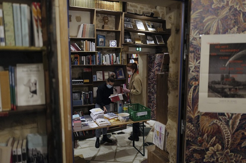 Employees sort books in the English and American literature Shakespeare and Co. bookstore, in Paris, France, Thursday, Nov. 05, 2020. Iconic Parisian bookshop Shakespeare and Co. has launched a support appeal to its readers after its owners say that coronavirus-linked losses, and a crippling months-long lockdown, have left the future of the veritable institution in doubt. "We've been minus 80 percent since the first confinement in March, so at this point we've used all our savings," Sylvia Whitman, daughter of the shop's co-founder George Whitman, told the Associated Press. (AP Photo/Francois Mori)