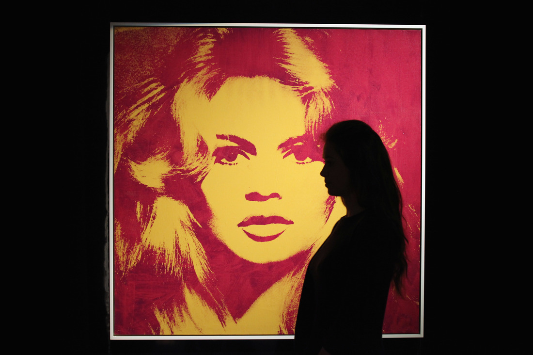 A woman stands in front of Andy Warhol's Brigitte Bardot at Sotheby's auction house in London on May 12, 2012.